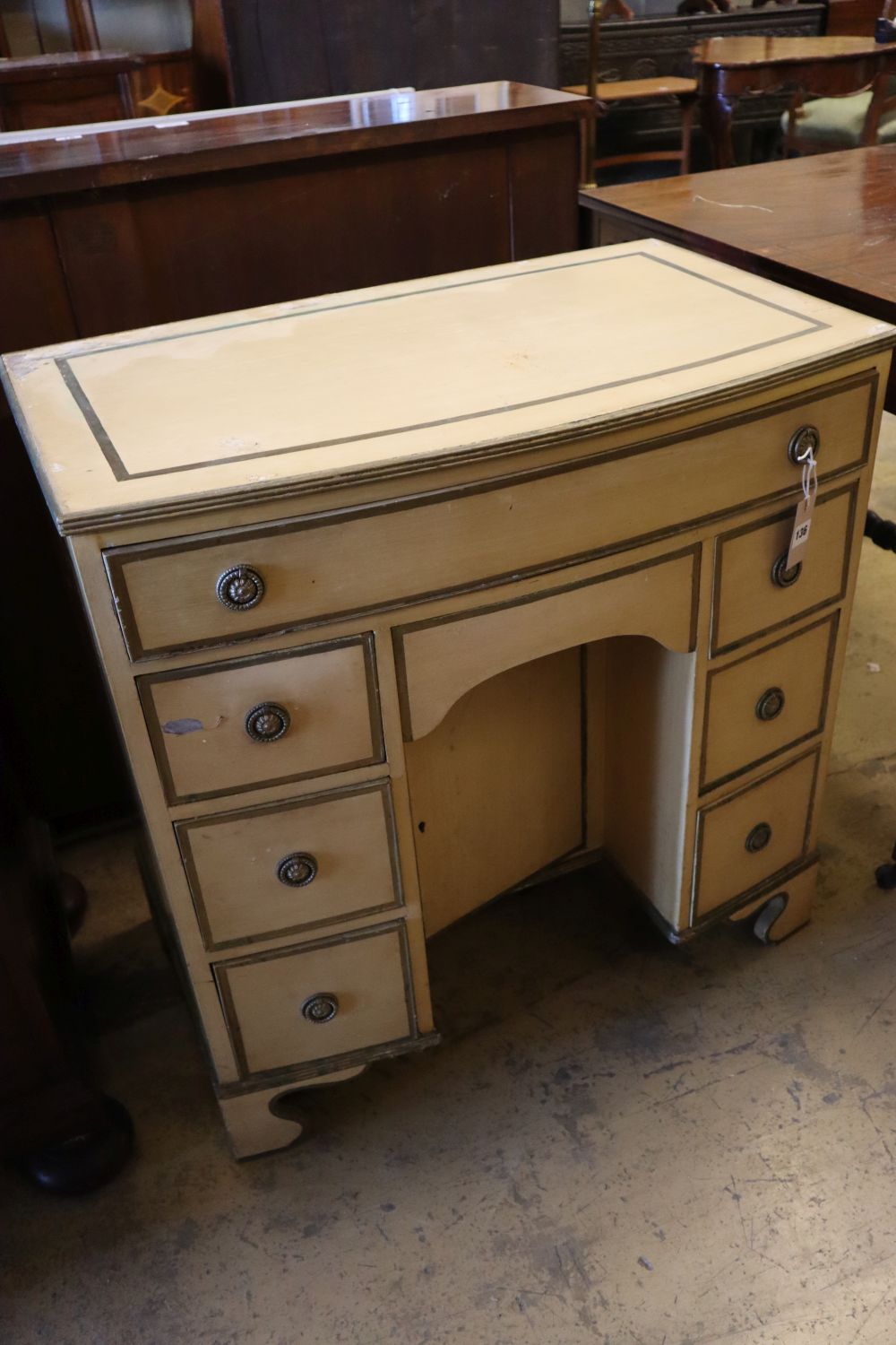 An early 20th century parcel gilt cream painted bowfront kneehole desk, width 78cm